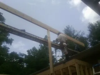 Carpenter setting a ridge beam over a new addition frame — Ice Dam Removal by Roofing Brothers in Mascotte